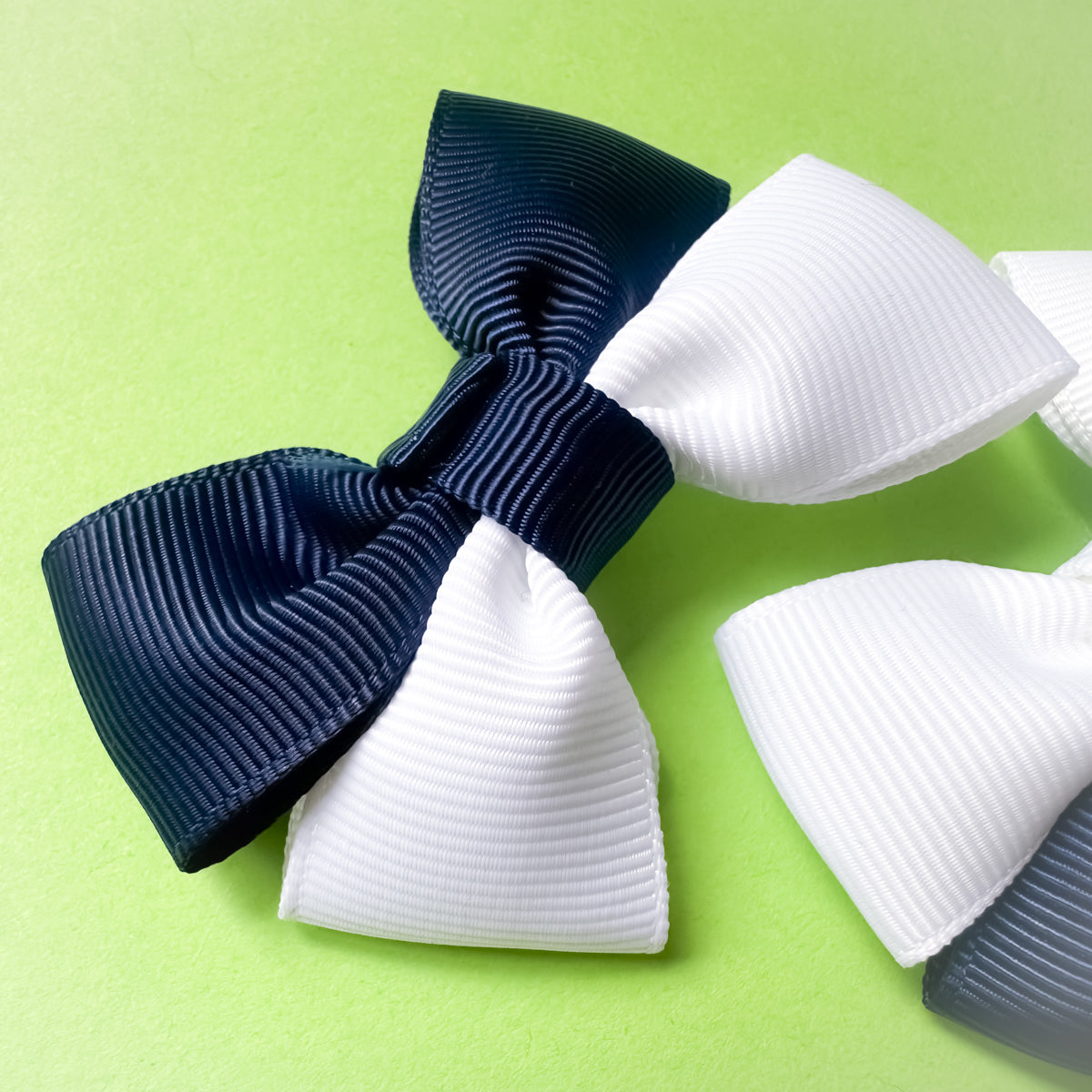 Close up of handmade navy blue and white Scotland hair bow clips for football match days and World Cup celebrations.