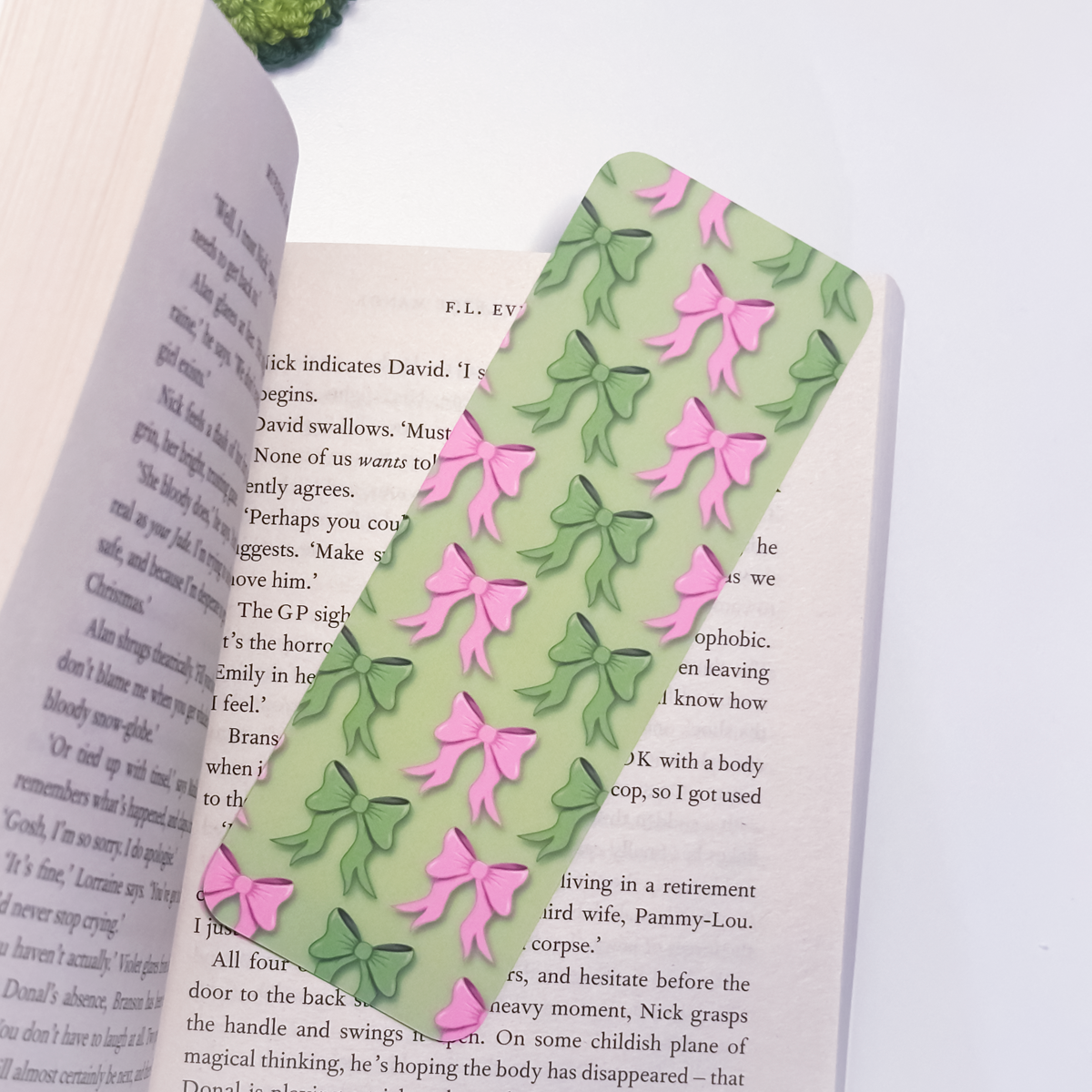 Green bookmark with pink and green bows on an open book
