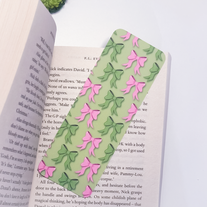Green bookmark with pink and green bows on an open book