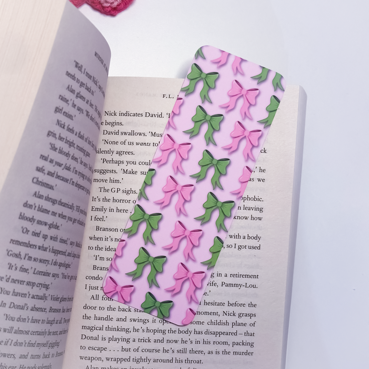 Pink bookmark with pink and green bows on an open book