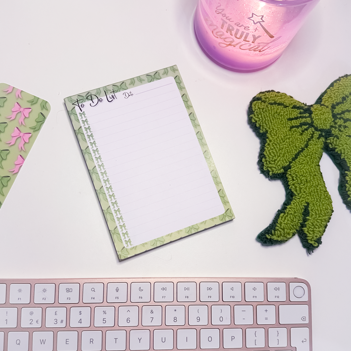 Green Bows To Do List A6Notepad with decorative green bows border, pink keyboard, and green bow mug rug on a white surface
