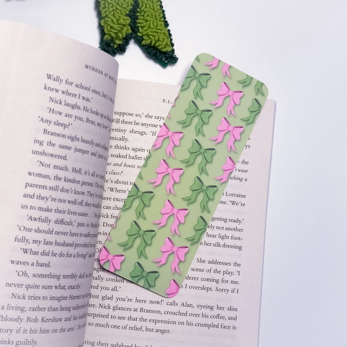 Green bookmark with pink and green bows on an open book