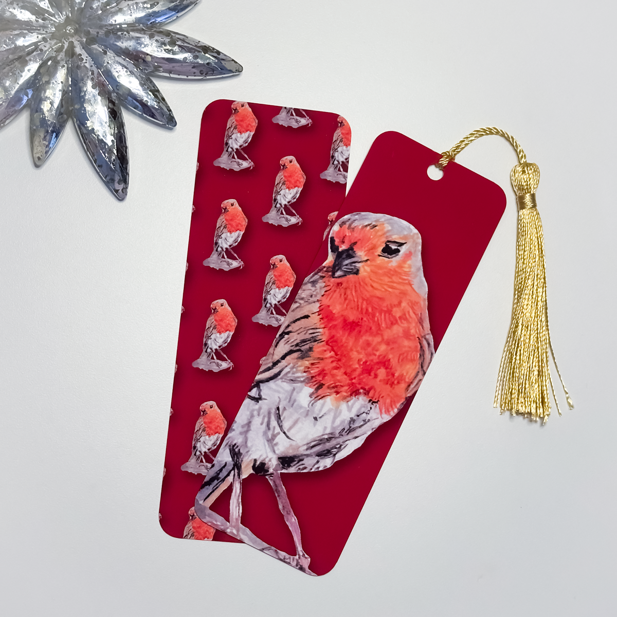 Red bookmarks with a robin design and a gold tassel